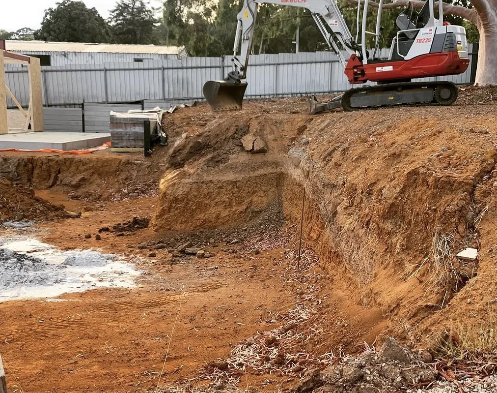 Mini excavator carrying out a residential site cut