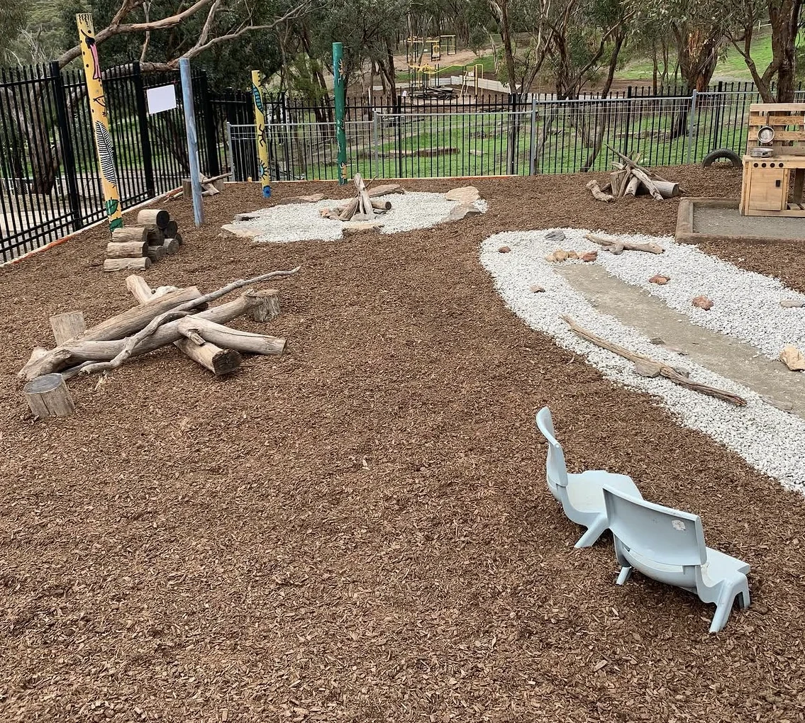 Nature play space with timber logs, gravel channels, rocks and mulch