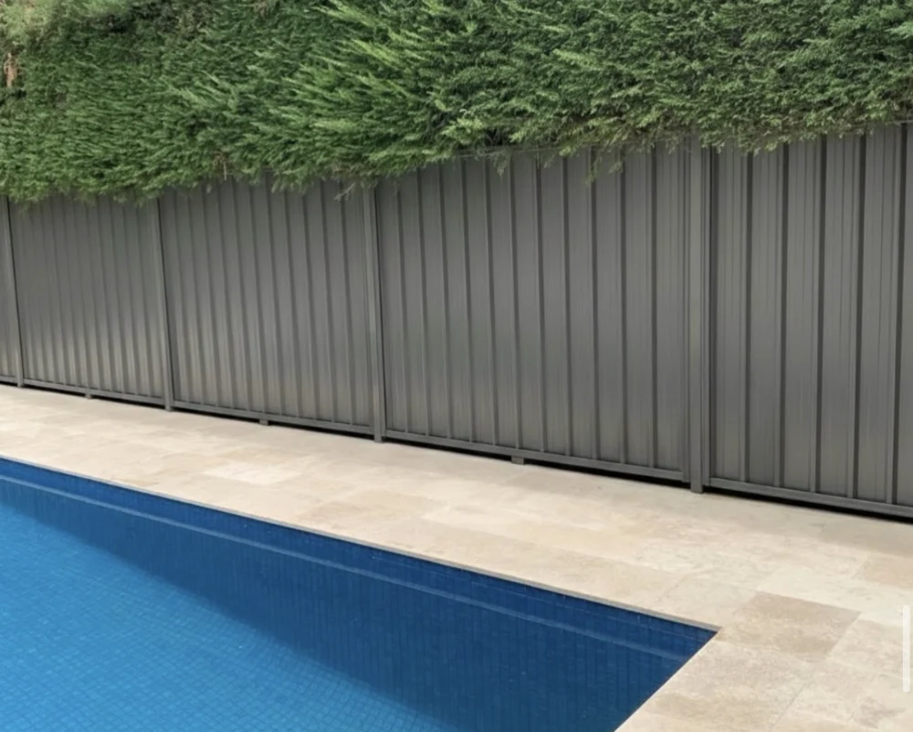 Pool with light stone paving and planted surrounds